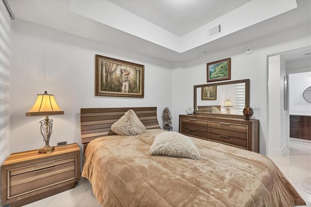 tiled bedroom with a raised ceiling