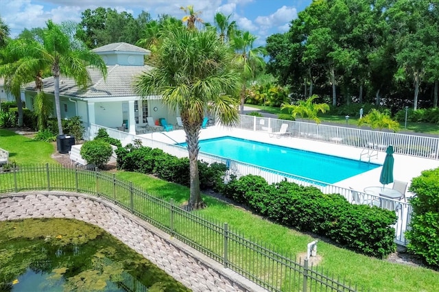 community pool featuring a patio area, fence, and a lawn