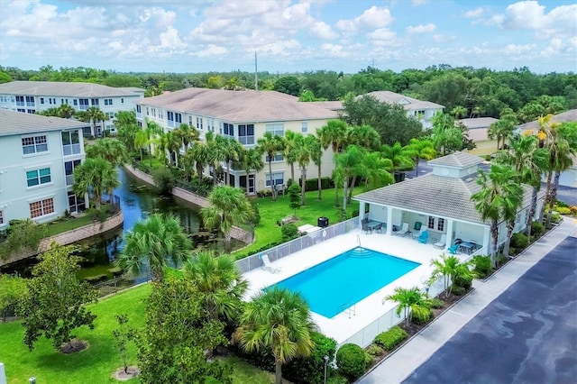 community pool featuring a yard, a patio area, a fenced backyard, and a residential view