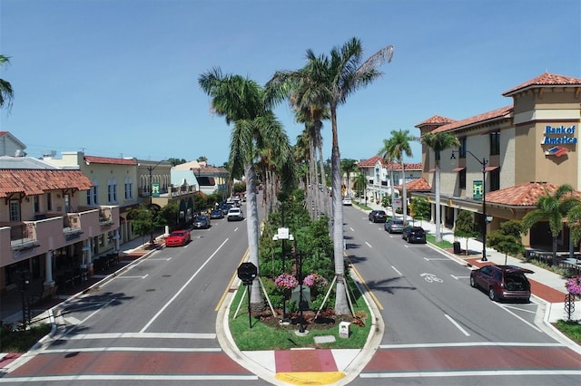 view of road featuring street lights, curbs, sidewalks, and a residential view