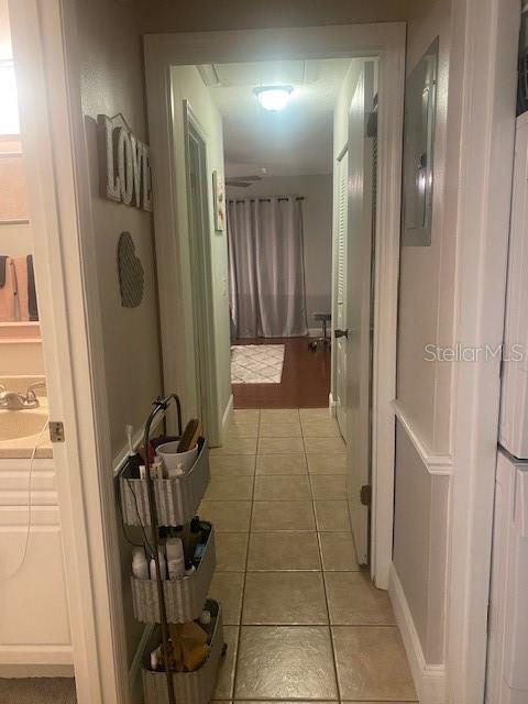 hallway with sink and tile patterned floors