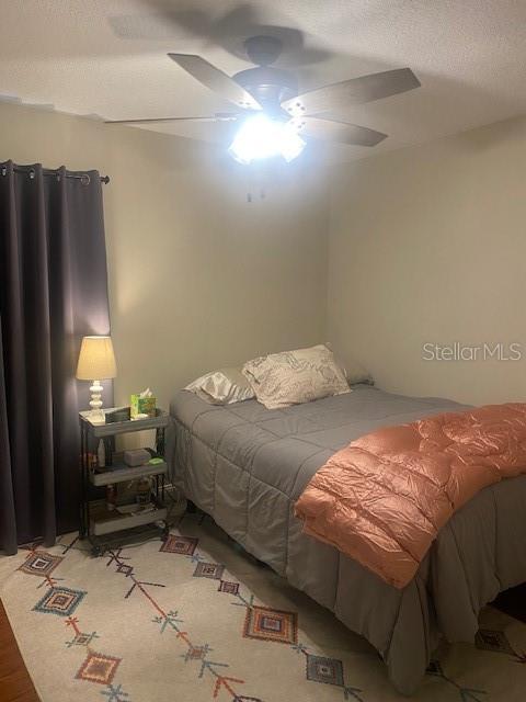 bedroom featuring ceiling fan and a textured ceiling