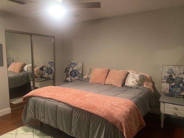 bedroom with ceiling fan, a closet, and dark hardwood / wood-style flooring