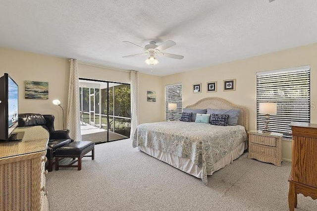 carpeted bedroom featuring access to exterior, ceiling fan, and a textured ceiling