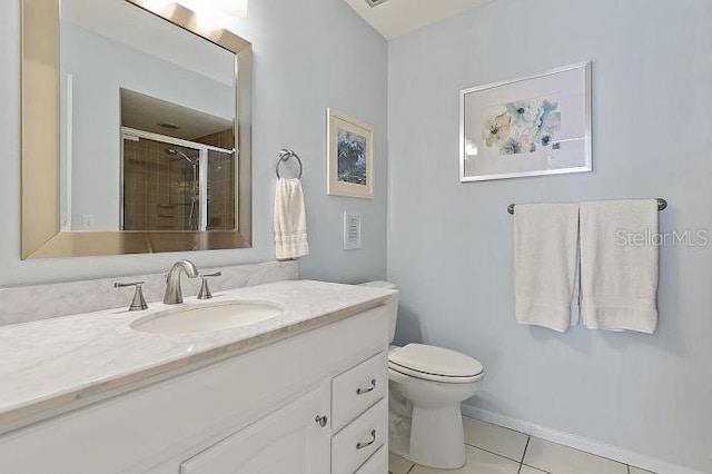 bathroom featuring tile patterned floors, vanity, toilet, and a shower with shower door