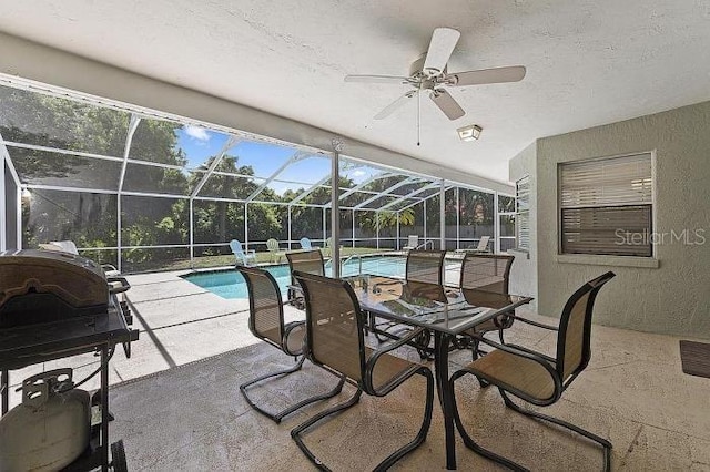 view of pool with a patio, glass enclosure, and ceiling fan