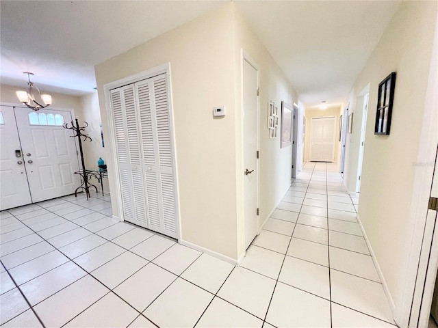 foyer entrance with light tile patterned flooring and a notable chandelier