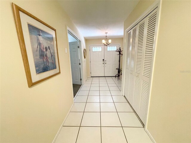 doorway with light tile patterned floors and a chandelier