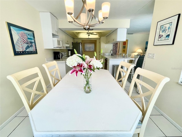 dining area featuring light tile patterned floors, sink, and a chandelier