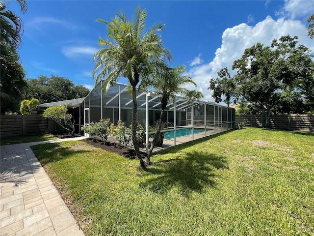 view of yard with a fenced in pool and a lanai