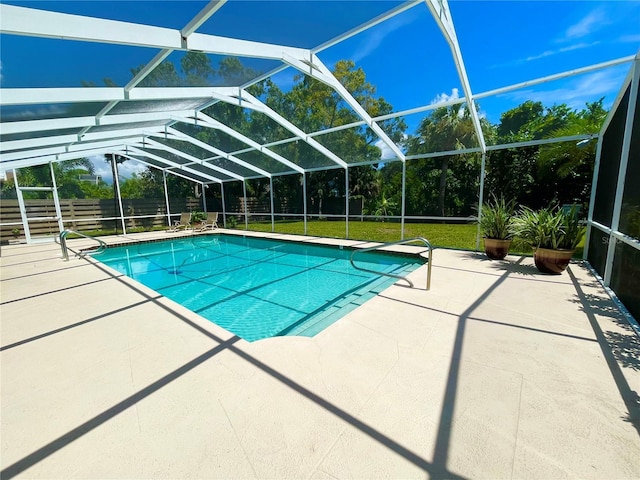 view of pool featuring glass enclosure, a patio area, and a lawn