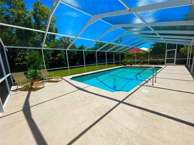 view of swimming pool featuring a lanai, a patio area, and a yard