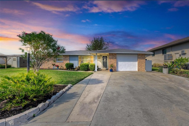 ranch-style house with a garage and a yard