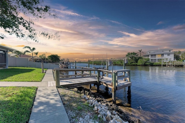 dock area featuring a water view and a lawn