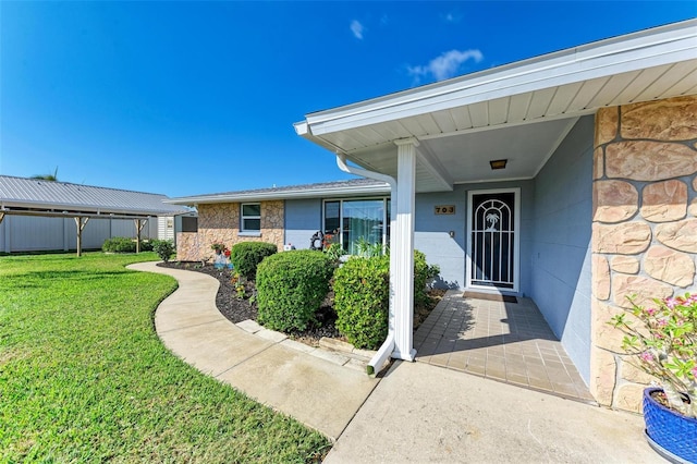 property entrance with a lawn