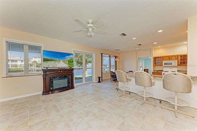 kitchen with white appliances, ceiling fan, a kitchen breakfast bar, and kitchen peninsula