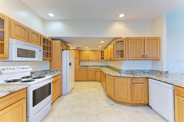 kitchen featuring white appliances and light stone countertops