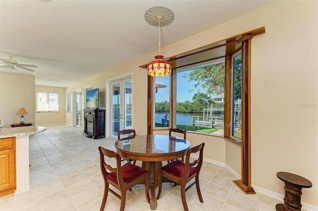 tiled dining room with french doors and ceiling fan