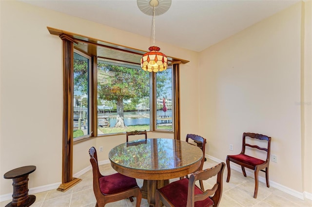 dining room featuring a water view and light tile patterned floors