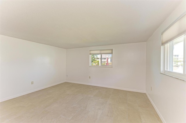 empty room featuring plenty of natural light and a textured ceiling