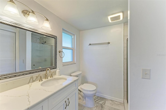 bathroom featuring toilet, a shower with door, and vanity