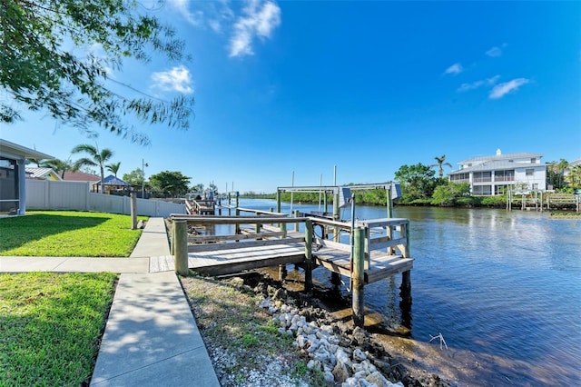 view of dock featuring a lawn and a water view