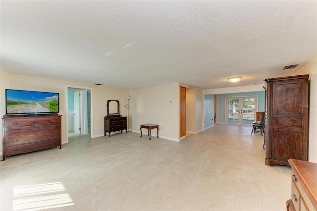 living area with a textured ceiling and french doors