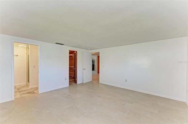 spare room with a textured ceiling