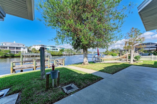 view of yard with a water view and a boat dock