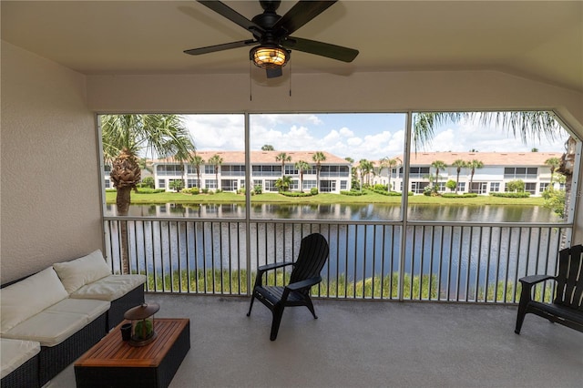 sunroom with ceiling fan, lofted ceiling, and a water view