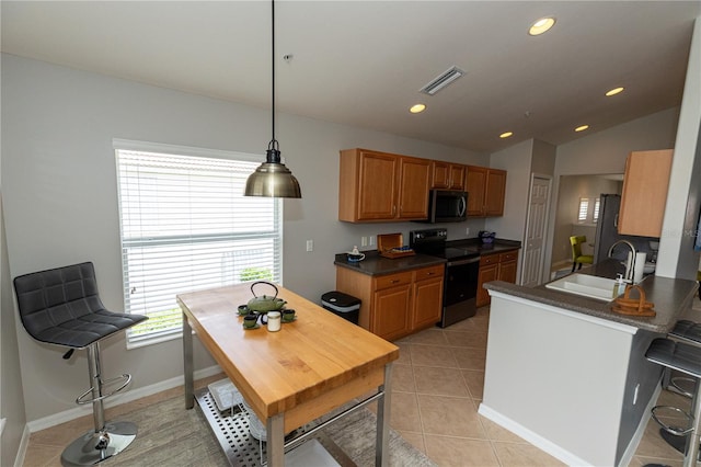 kitchen featuring electric stove, pendant lighting, vaulted ceiling, light tile patterned floors, and sink