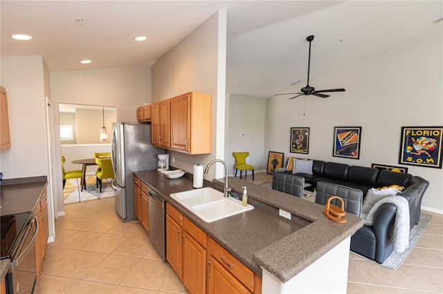 kitchen featuring ceiling fan, lofted ceiling, appliances with stainless steel finishes, sink, and light tile patterned flooring