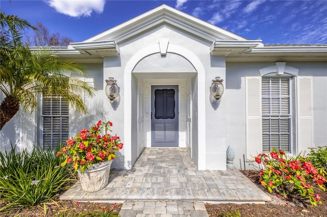 entrance to property featuring stucco siding