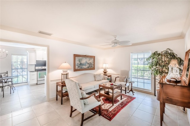 living room featuring light tile patterned floors, plenty of natural light, and ceiling fan with notable chandelier