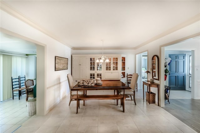 dining area featuring light tile patterned flooring, a notable chandelier, and ornamental molding