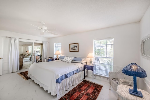 bedroom featuring multiple windows and ceiling fan