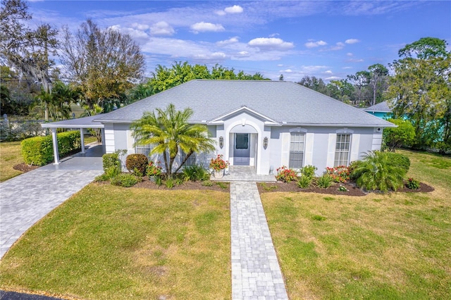 ranch-style house featuring a carport and a front lawn