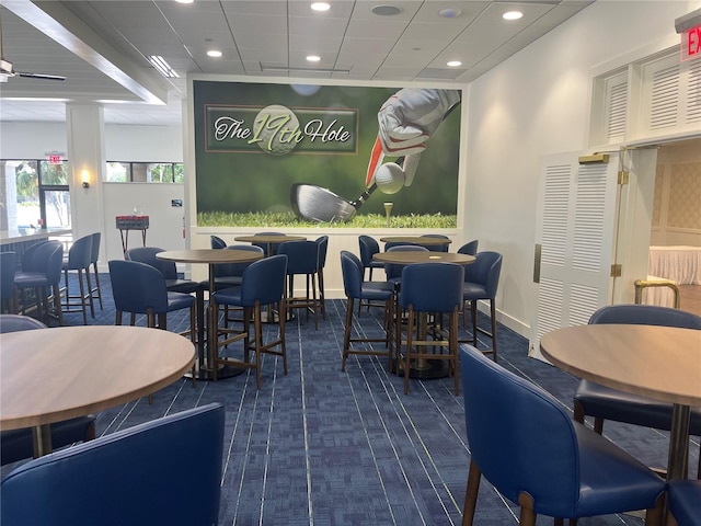 carpeted dining space featuring ceiling fan