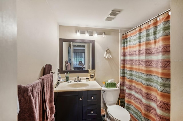 bathroom with toilet, vanity, and curtained shower