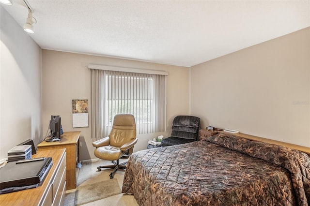 carpeted bedroom with a textured ceiling and rail lighting