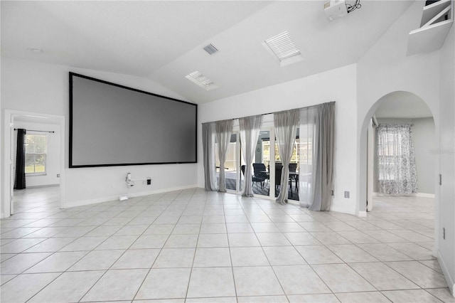 home theater room with high vaulted ceiling and light tile patterned flooring