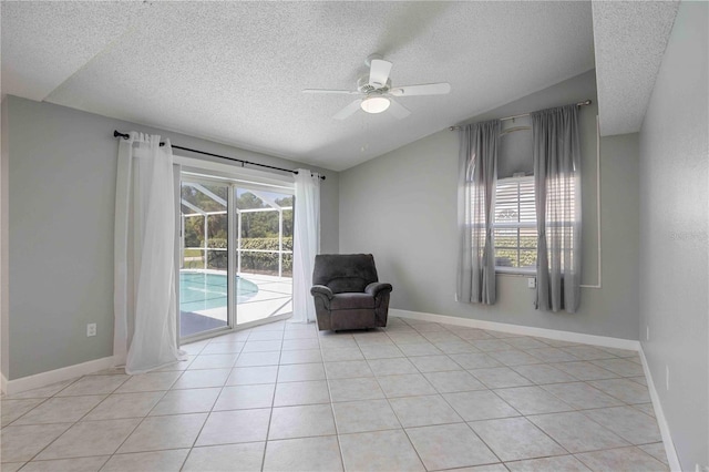 unfurnished room with light tile patterned flooring, ceiling fan, a textured ceiling, and vaulted ceiling