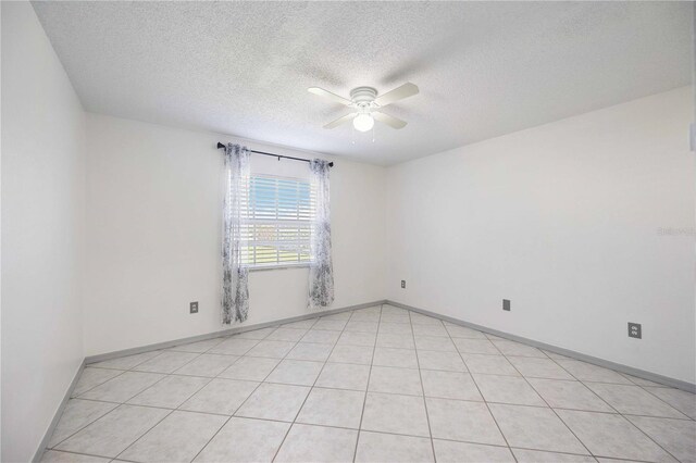 tiled spare room featuring a textured ceiling and ceiling fan