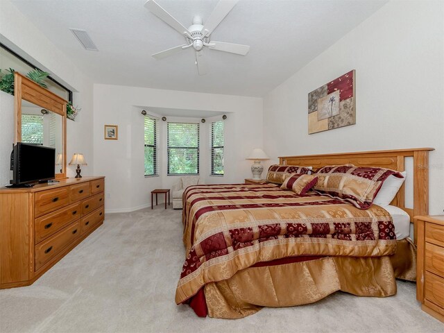 carpeted bedroom featuring multiple windows and ceiling fan