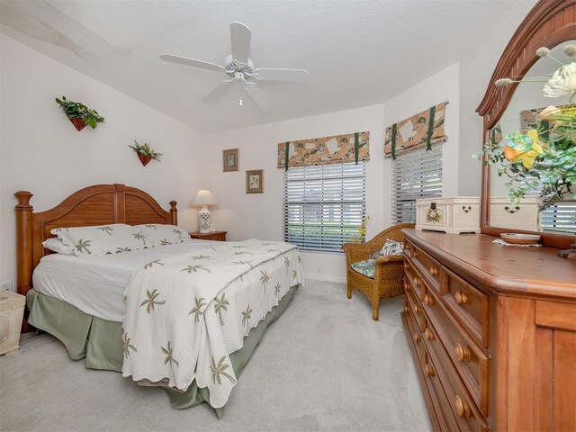 bedroom with ceiling fan and light carpet