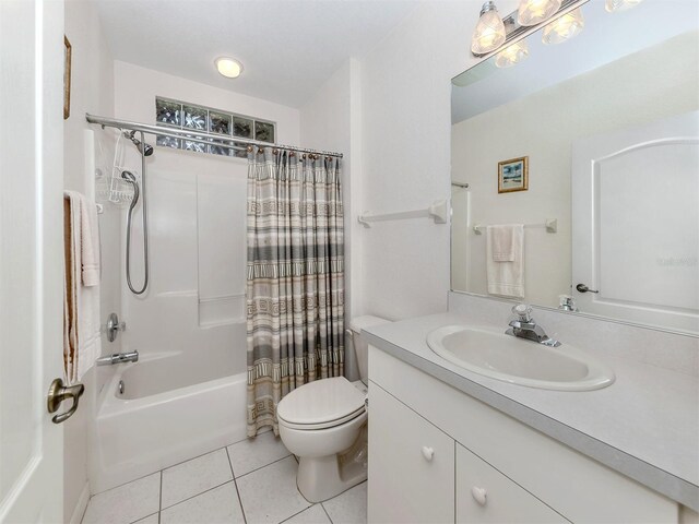 full bathroom featuring tile patterned floors, toilet, shower / bath combo with shower curtain, and vanity