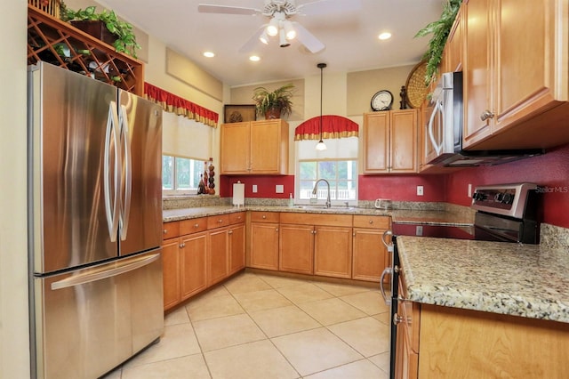 kitchen with light tile patterned floors, stainless steel appliances, sink, ceiling fan, and pendant lighting