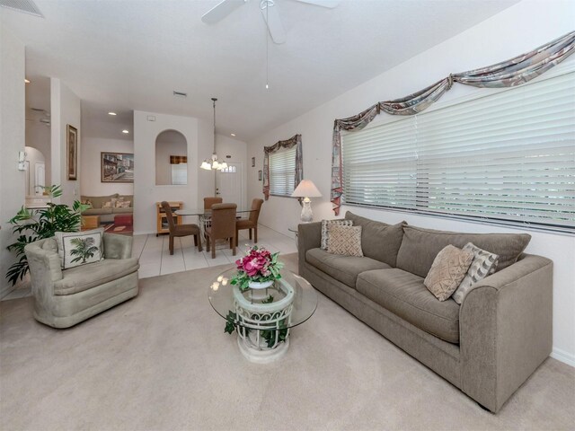 living room with ceiling fan with notable chandelier and light carpet