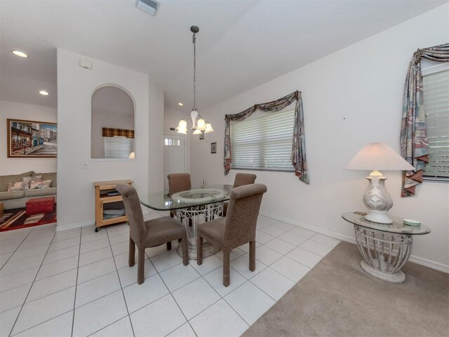 tiled dining area featuring vaulted ceiling and a notable chandelier