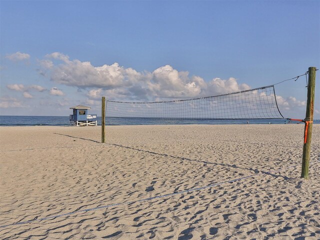 view of community with a water view, a view of the beach, and volleyball court